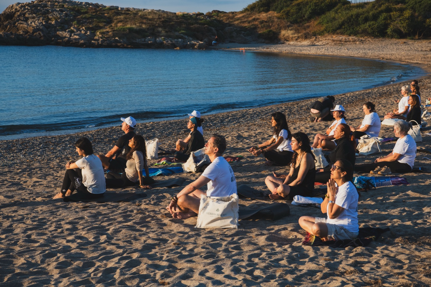 Meditazione in cerchio sulla spiaggia, luce del mattino